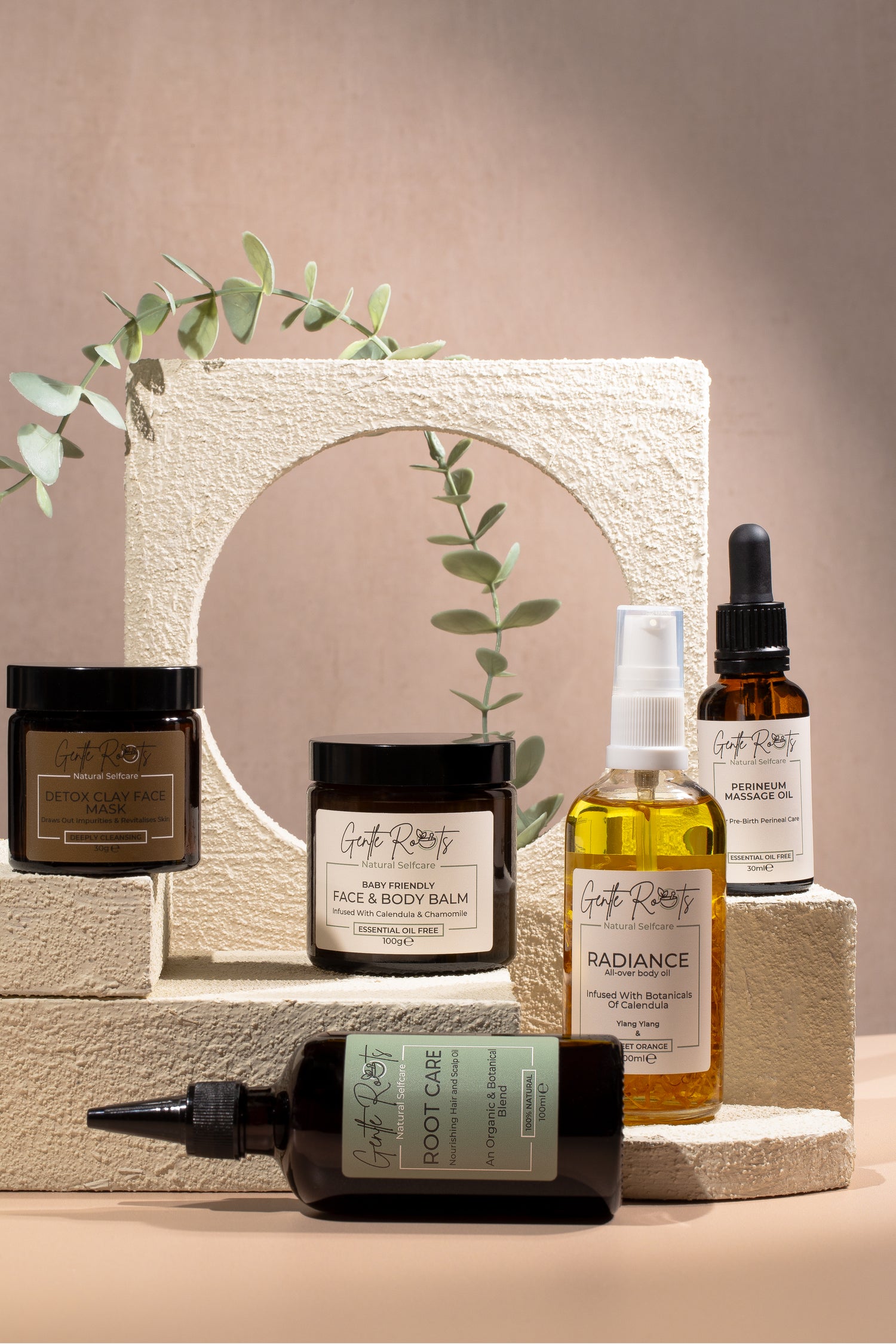Collection of natural skincare products on a neutral background with a plant.