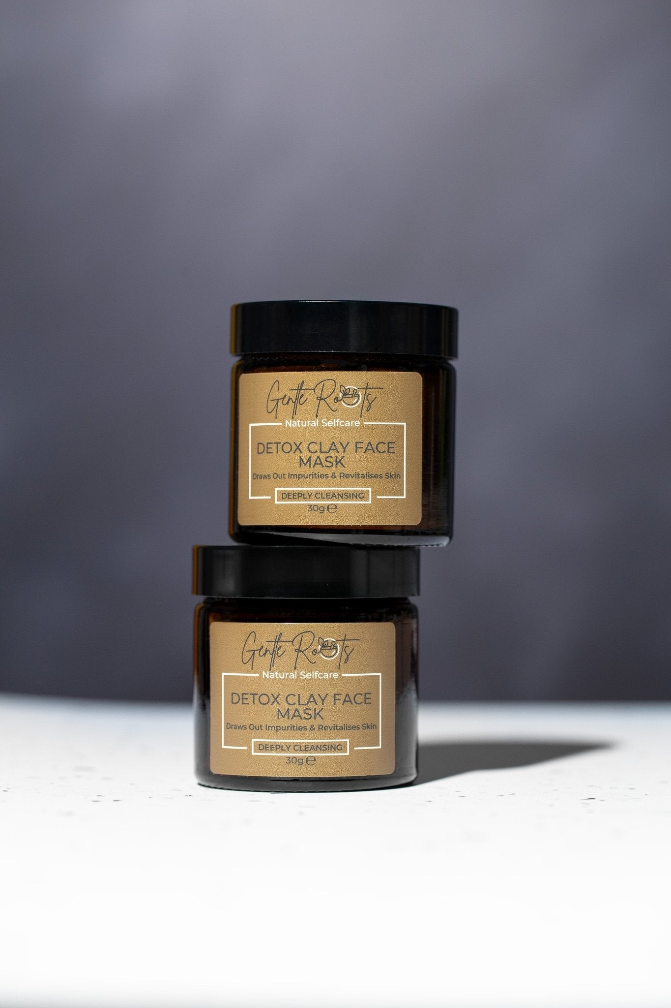 Gentle Roots Detox Clay Face Mask jars stacked on neutral background – eco-friendly glass packaging.