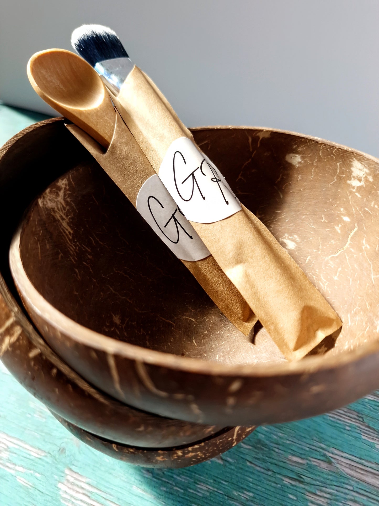Gentle Roots coconut masking bowl with bamboo brush and spoon for mixing clay masks.