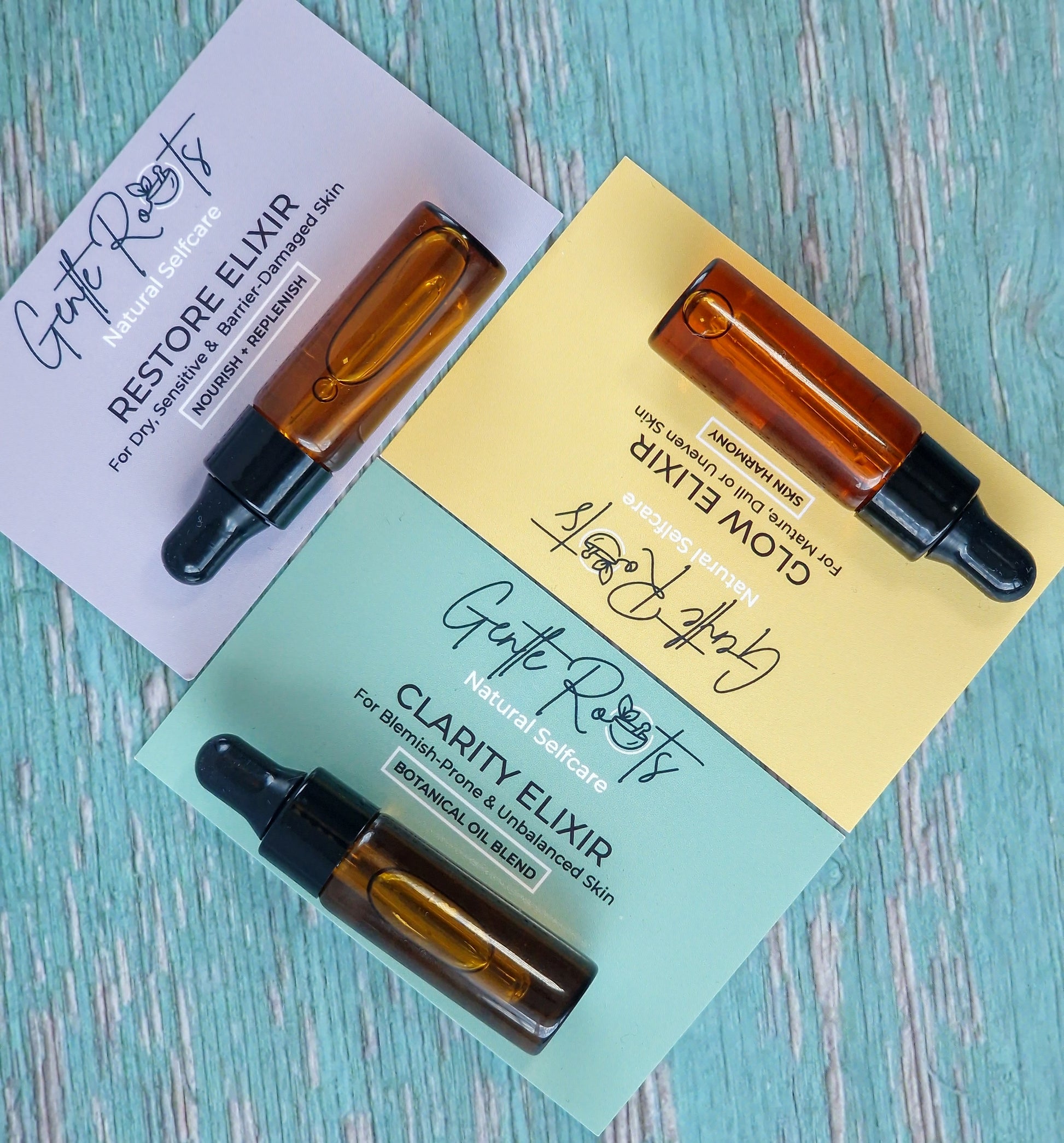 Close-up of Glow, Restore & Clarity Mini Elixirs with cards