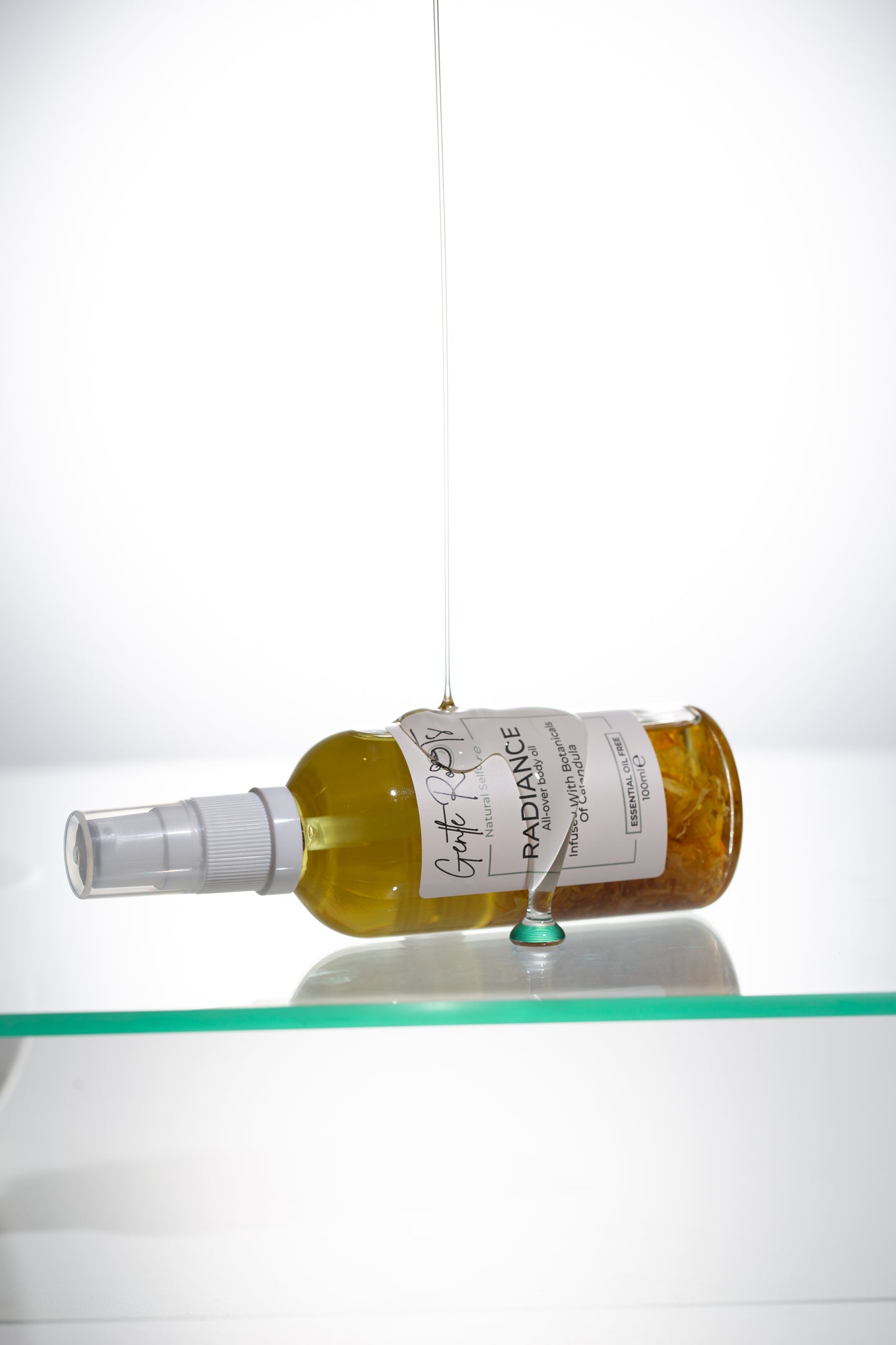 Radiance Body Oil bottle lying flat with reflection as part of the gift set