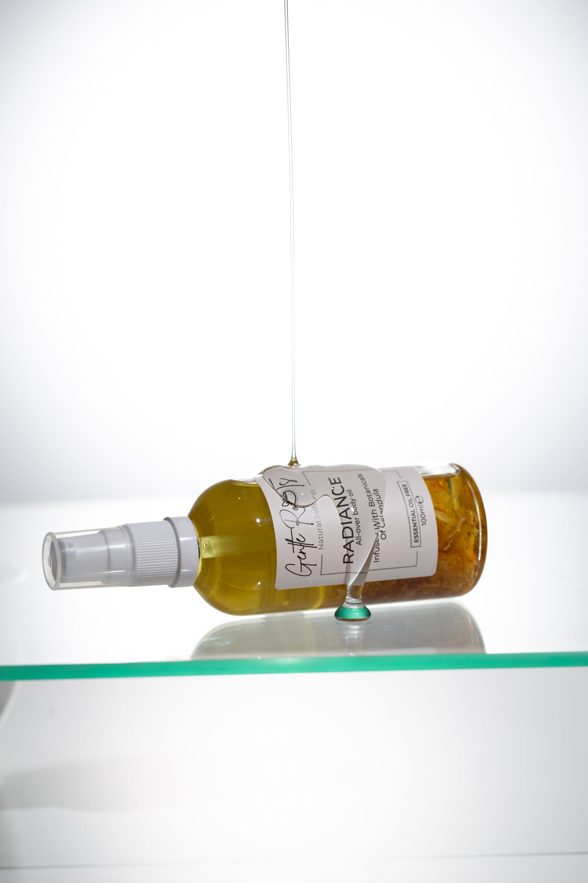 Radiance Body Oil bottle lying flat with reflection as part of the gift set